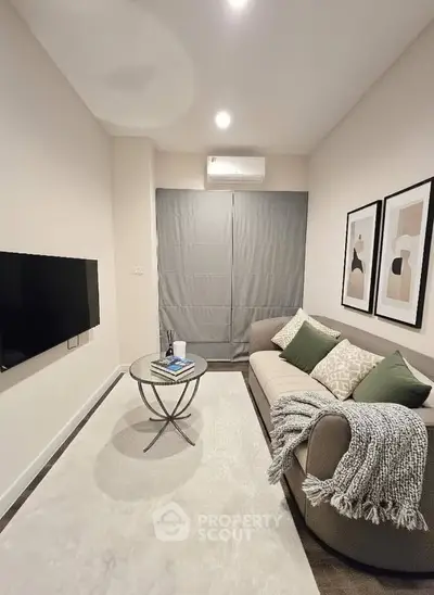 Cozy living room with modern decor, featuring a plush sofa, stylish coffee table, and wall-mounted TV.