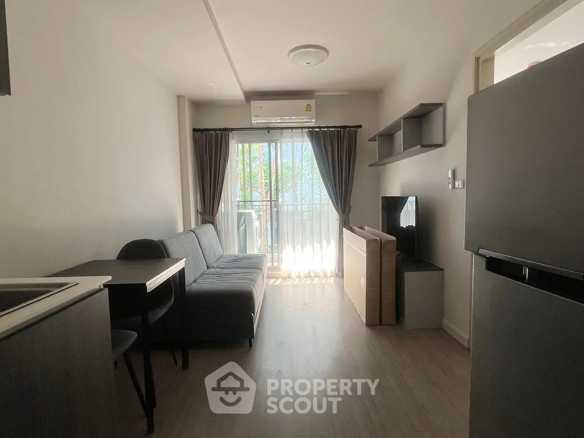 Modern living room with balcony, featuring sleek furniture and natural light, perfect for urban living.