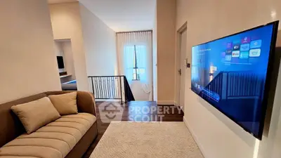 Modern living area with wall-mounted TV and cozy sofa in a stylish home interior.