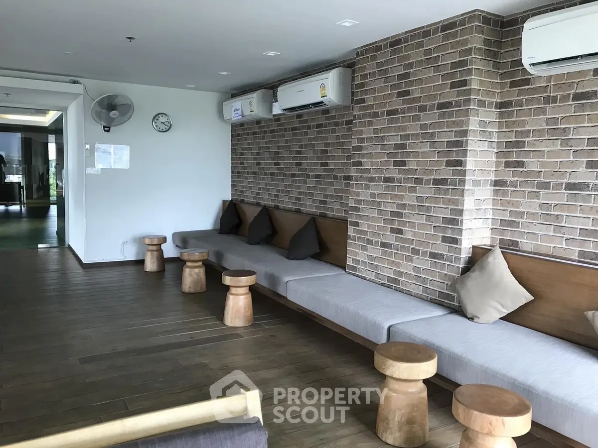 Stylish common area with brick accent wall and modern seating in a contemporary building.