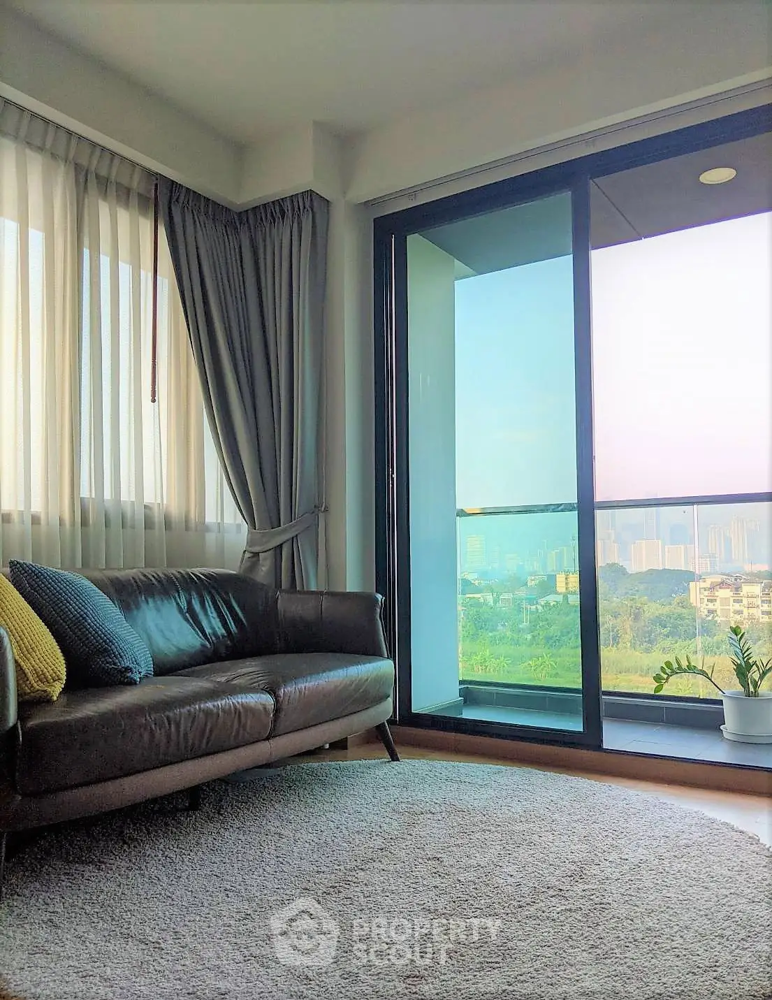 Stylish living room with leather sofa and city view balcony