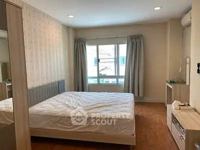 Spacious bedroom with modern decor and large window for natural light