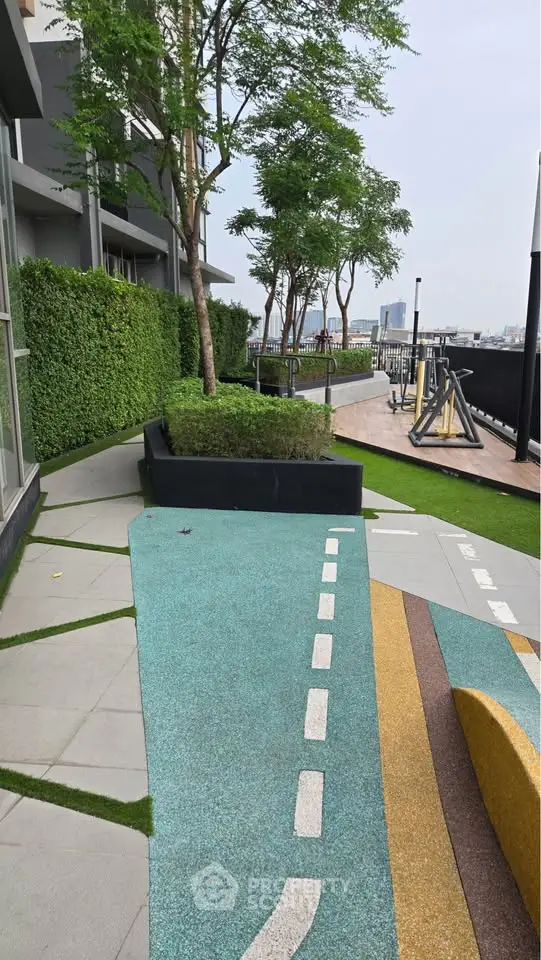 Modern outdoor garden area with vibrant pathways and lush greenery in a residential complex.