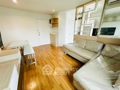 Modern living room with wooden flooring and stylish furniture in a bright apartment.