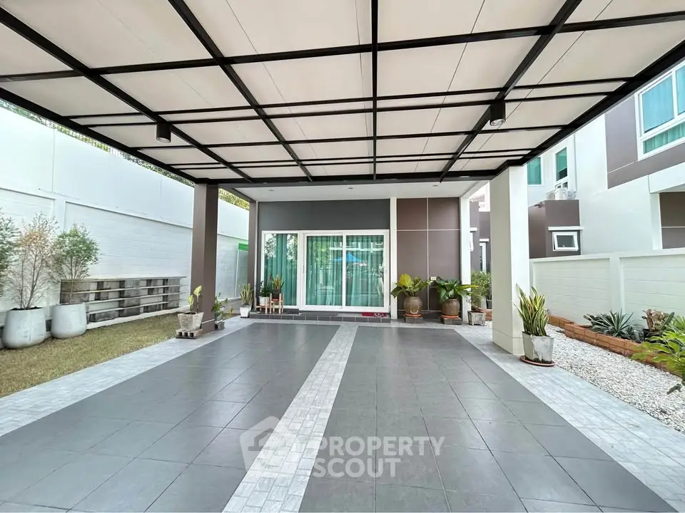 Modern covered parking area with stylish tiles and garden accents