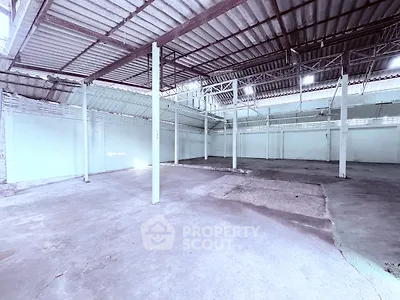 Spacious industrial warehouse with high ceilings and open floor plan, ideal for storage or manufacturing.