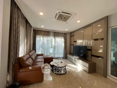 Spacious living room with modern leather sofa and large TV unit
