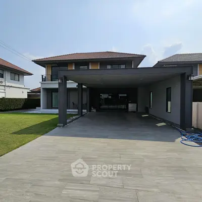 Spacious modern house with large driveway and manicured lawn in a serene neighborhood.