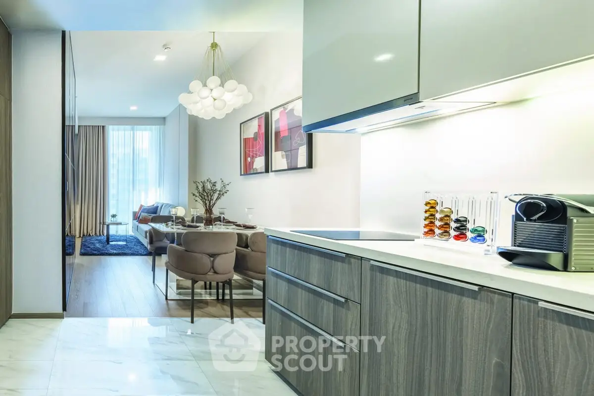Modern open-layout kitchen and living room with stylish decor and natural light.