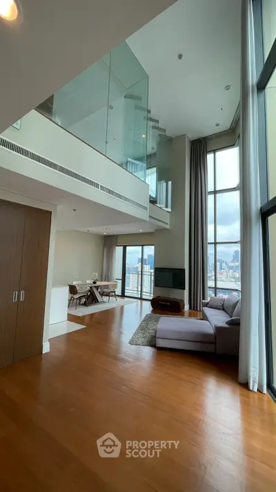 Luxurious high-ceiling living room with panoramic city views and modern decor.