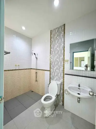 Modern bathroom with sleek tiles and contemporary fixtures in a spacious layout.