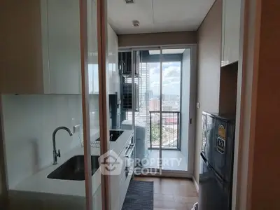 Modern kitchen with city view, featuring sleek appliances and ample natural light.