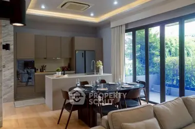 Modern open-layout kitchen and dining area with large windows and garden view.
