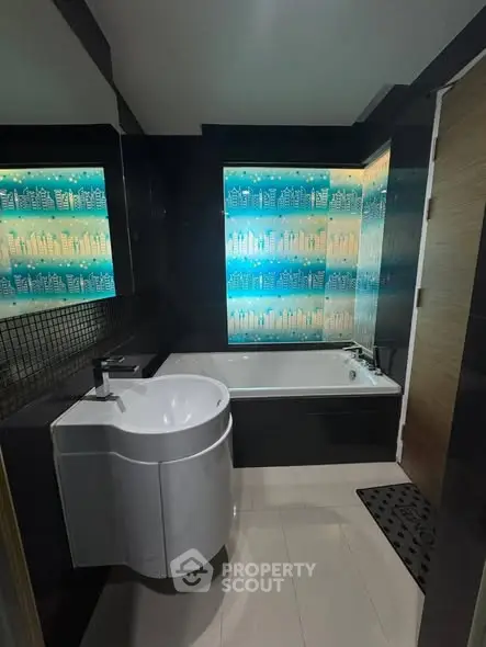 Modern bathroom with sleek design and illuminated bathtub feature.