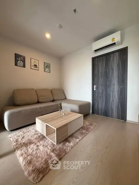Modern living room with cozy sofa, stylish coffee table, and wall art in a contemporary apartment.