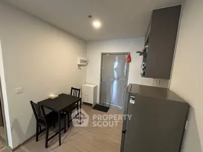 Modern kitchen with sleek design, featuring a dining table and stainless steel appliances.