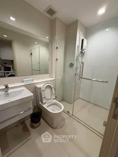 Modern bathroom with glass shower and sleek fixtures in a contemporary apartment.