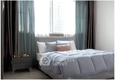 Spacious bedroom with modern decor and large window offering natural light.