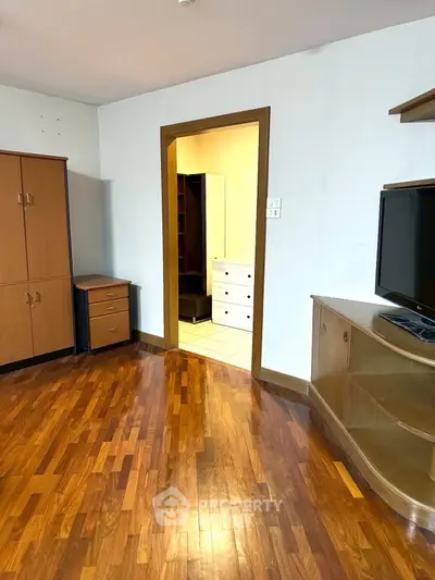 Spacious room with wooden flooring and modern furniture, ideal for cozy living.