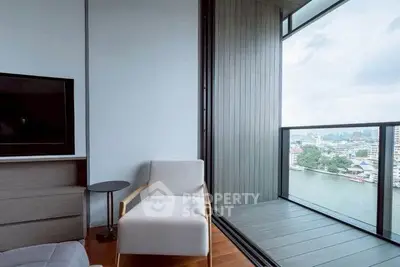 Modern apartment with a cozy chair and stunning river view from the balcony.