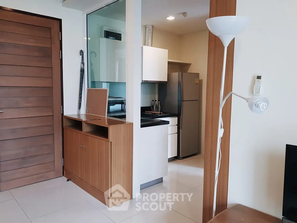 Modern kitchen with sleek appliances and wooden cabinetry in a stylish apartment.
