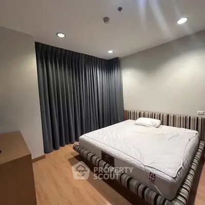 Spacious bedroom with modern design and cozy ambiance, featuring a comfortable bed and elegant lighting.
