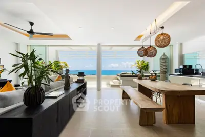 Luxurious open-plan living room with ocean view, modern decor, and natural light.