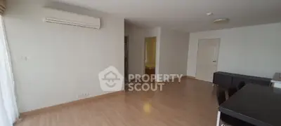 Spacious living room with wooden flooring and modern air conditioning unit.