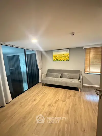 Modern living room with wooden flooring and stylish gray sofa