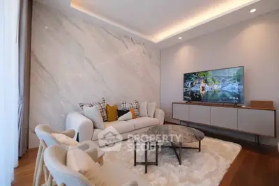 Luxurious living room with modern furniture and large TV, featuring elegant marble accent wall.