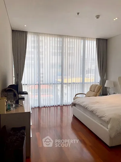 Elegant bedroom with floor-to-ceiling windows and hardwood floors