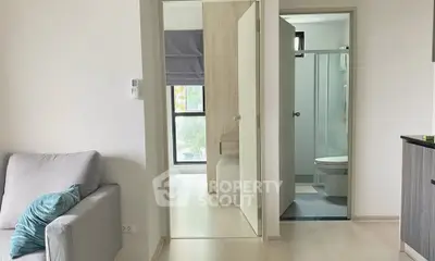 Modern apartment interior with cozy living room and adjacent bathroom, featuring sleek design and natural light.