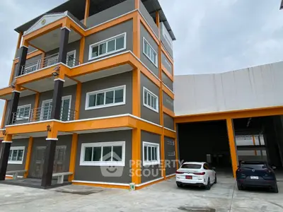 Modern multi-story building with parking area and sleek design, ideal for commercial use.