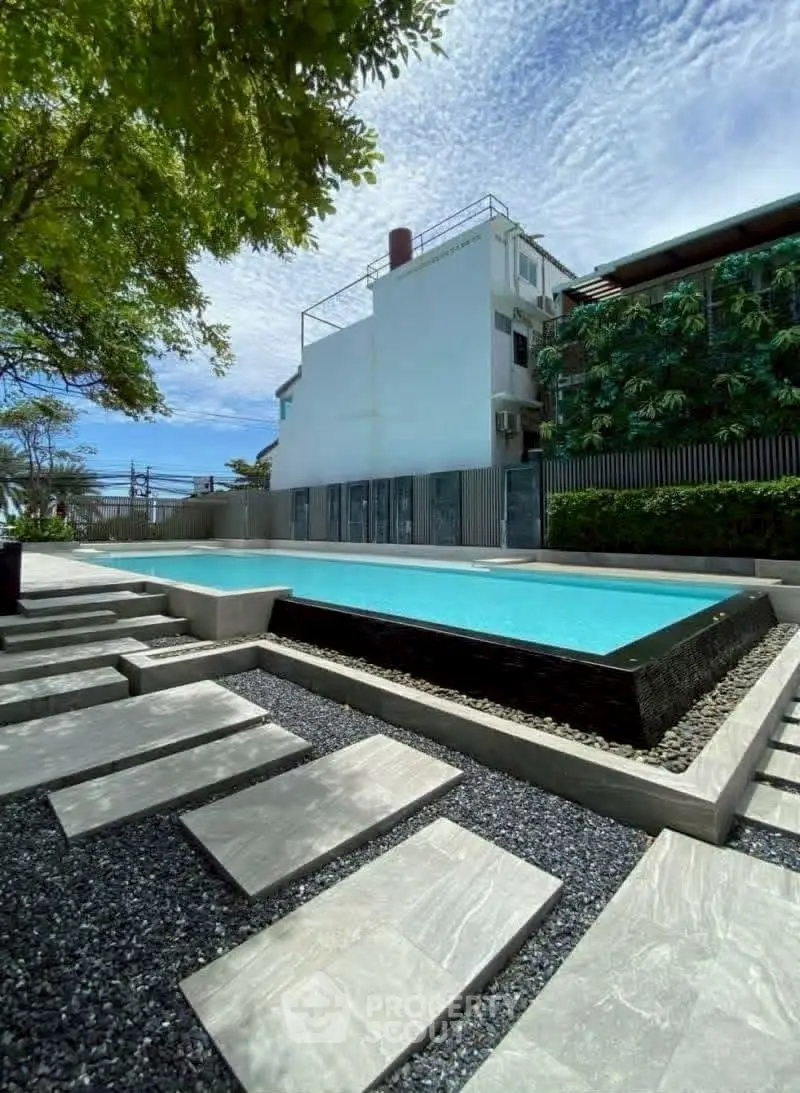 Stunning modern pool area with sleek design and lush greenery, perfect for relaxation and leisure.