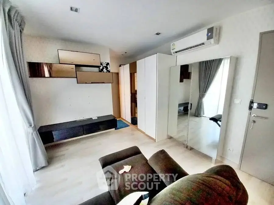 Modern living room with sleek design, featuring air conditioning and stylish wall decor.