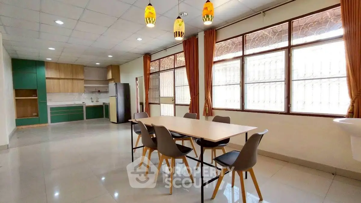 Spacious dining area with modern kitchen and large windows