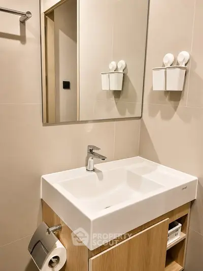 Modern bathroom with sleek sink and mirror in contemporary apartment.