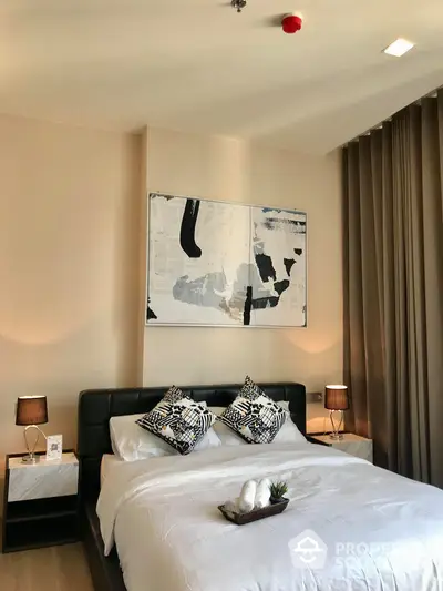 Elegant bedroom with modern art, neutral tones, and tasteful lighting, creating a serene and sophisticated sleeping space.