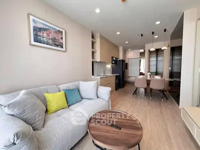 Modern open-plan living room with cozy sofa and stylish dining area in a contemporary apartment.