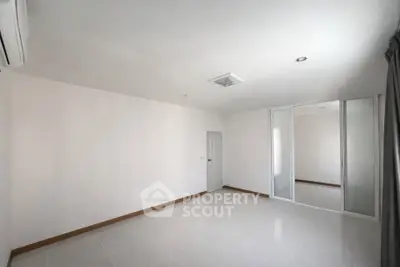 Spacious empty room with white walls and sliding closet doors, perfect for customization.