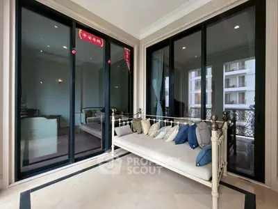 Luxurious balcony with elegant daybed and stunning view of modern architecture.