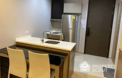 Modern kitchen with sleek design and stainless steel fridge in compact apartment