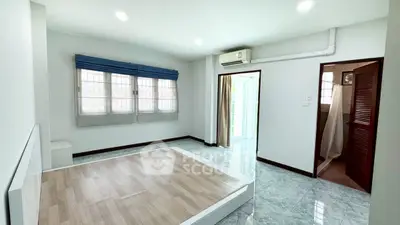 Spacious bedroom with large windows and modern flooring