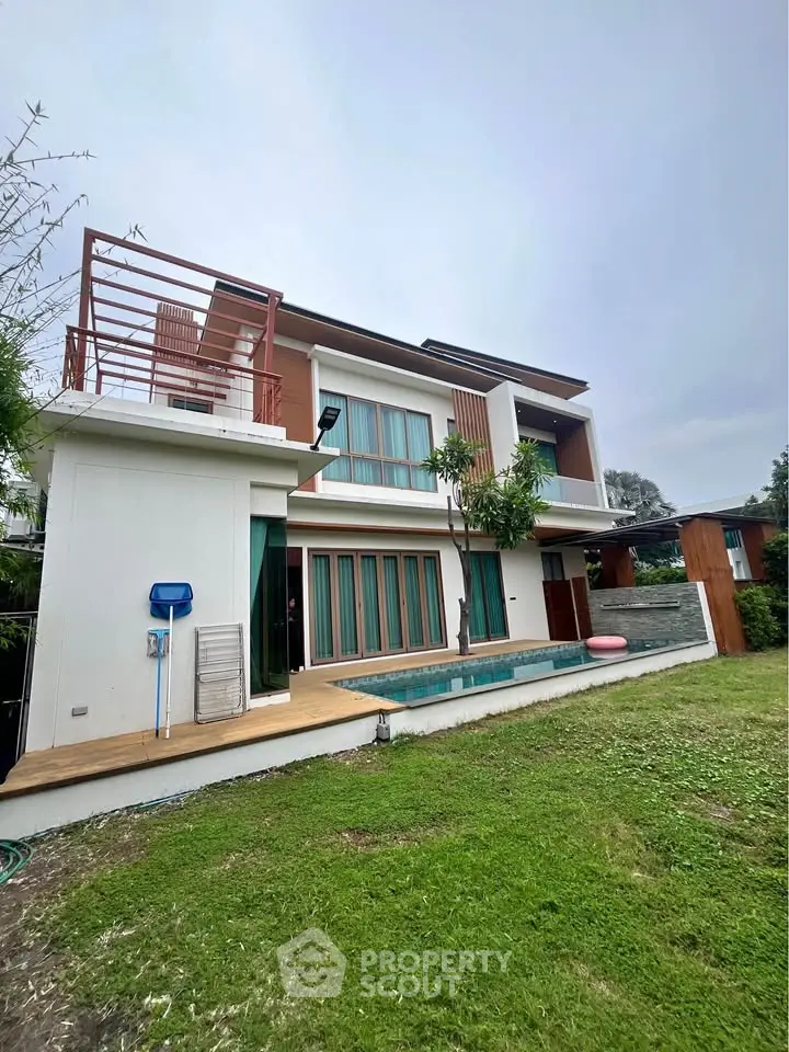 Modern two-story house with private pool and lush garden, featuring contemporary architecture and spacious outdoor area.