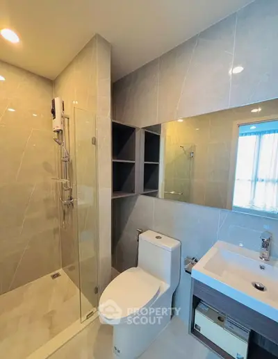 Modern bathroom with sleek design, featuring glass shower and elegant fixtures.