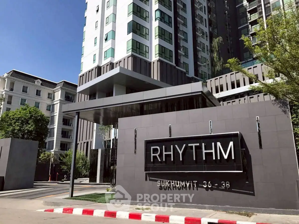 Modern condominium building exterior with sleek design at Rhythm Sukhumvit 36-38, showcasing urban living.