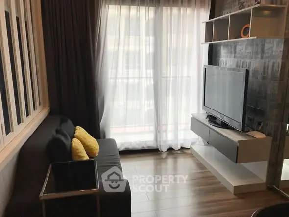 Modern living room with sleek furniture and large window for natural light.