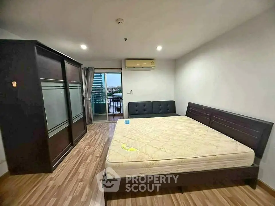 Spacious bedroom with large bed and wardrobe, featuring a balcony view.