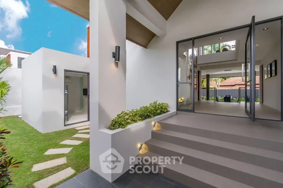 Modern home entrance with sleek design and lush greenery, showcasing contemporary architecture and inviting ambiance.