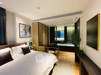 Luxurious bedroom with ensuite bathroom and modern decor in upscale apartment.